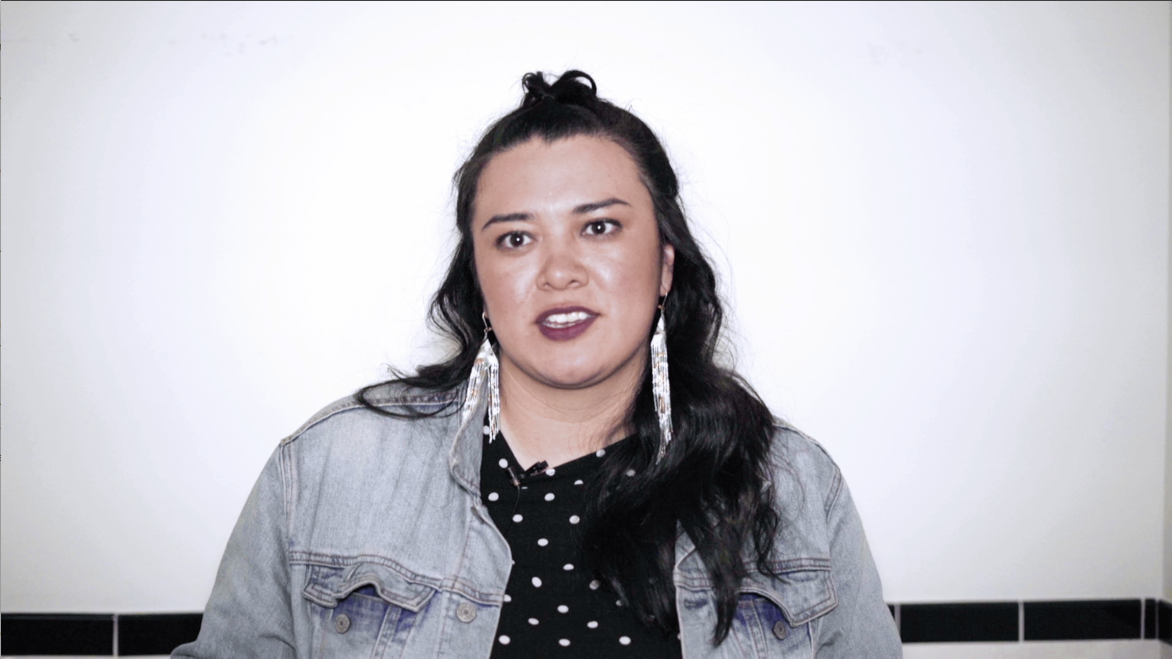 chubby girl with long earnings and wearing denim jacket